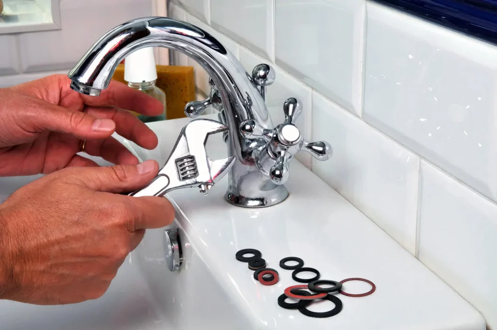 Plumber performing maintenance on a bathroom faucet in Acworth
