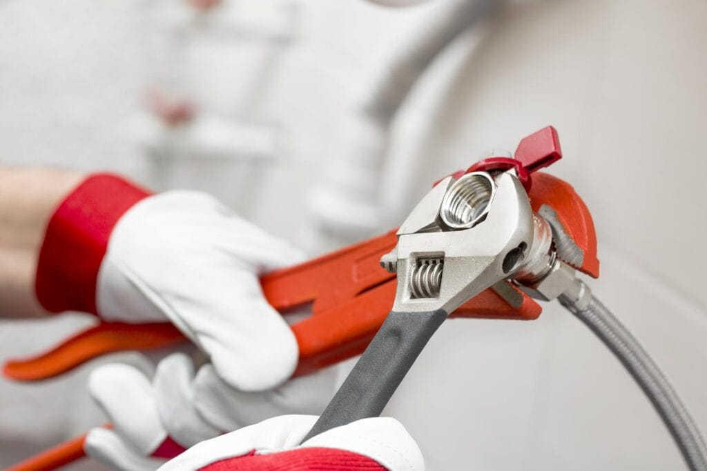 Plumber holding pipe wrenches for an emergency repair in Acworth