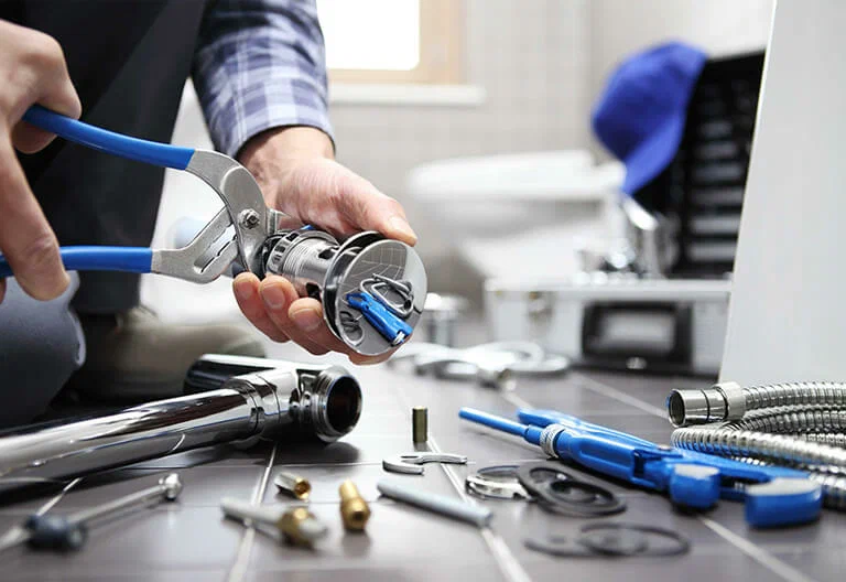 Technician repairing a plumbing fixture with professional tools in Acworth