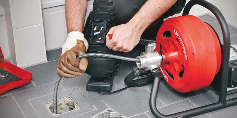 Plumber using a drain-cleaning machine in Acworth