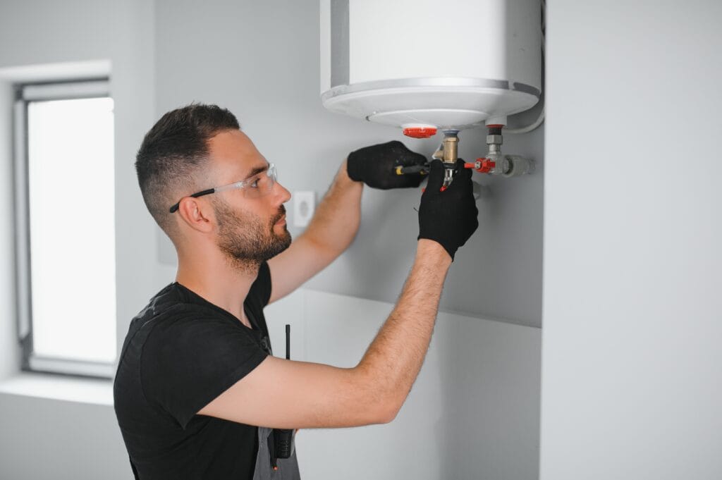 Technician performing water heater maintenance in Acworth