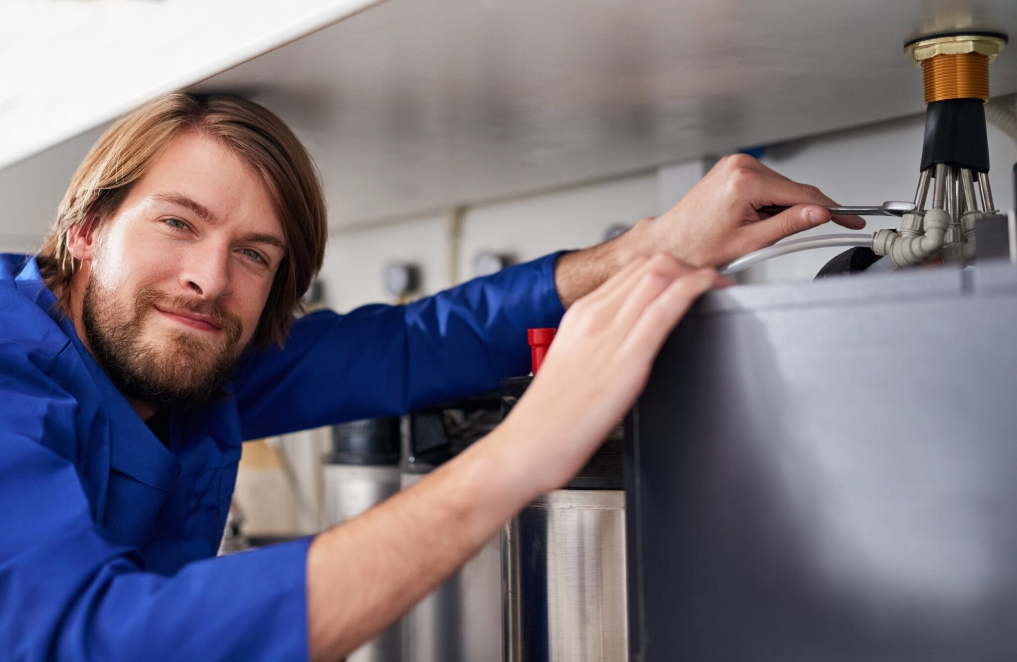 Technician servicing a residential water heater tank in Acworth