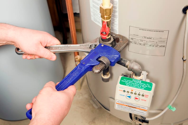Plumber repairing a water heater valve in Acworth